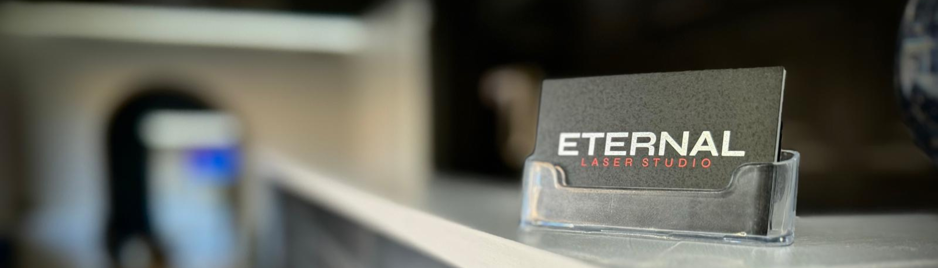 Eternal Laser Studio Walsall business card on a reception desk